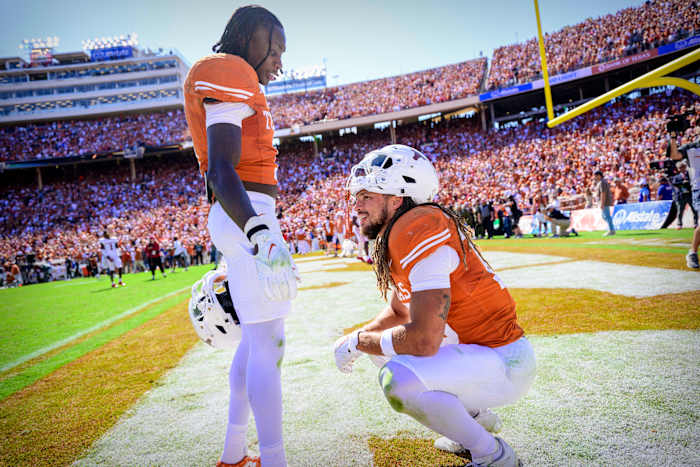 Texas Longhorns wide receiver Xavier Worthy (1) checks on wide receiver Jordan Whittington (13) after the Longhorns lose to the Oklahoma Sooners at the Cotton Bowl.