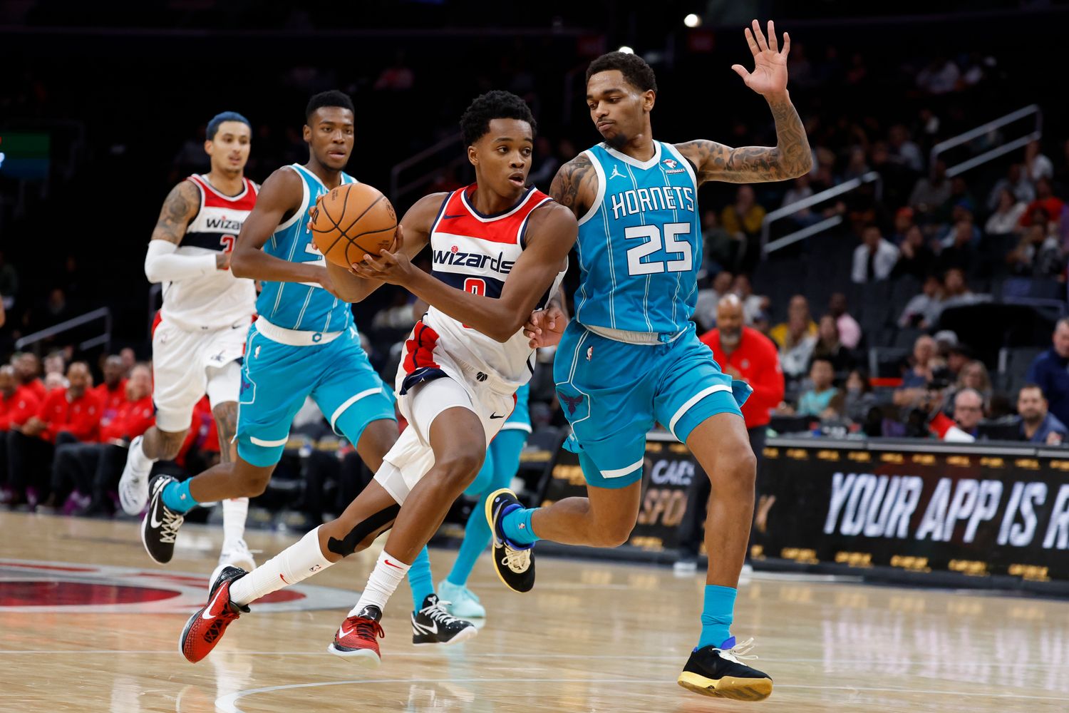 Washington Wizards guard Bilal Coulibaly (0) drives to the basket as Charlotte Hornets forward P.J. Washington (25) defends in the third quarter at Capital One Arena.