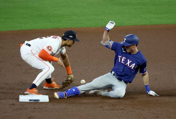 Texas Rangers outfielder Evan Carter, right, slides in with a double in front of Houston Astros shortstop Jeremy Pena during the first inning of Game 1 of the ALCS at Minute Maid Park on Oct. 15.