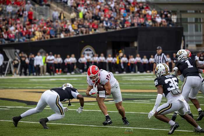 Brock Bowers catches a pass and is tackled low by Vanderbilt defenders Photo - Brooks Austin