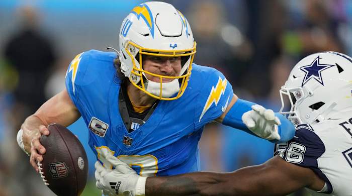 Chargers quarterback Justin Herbert attempts to evade a tackle by Cowboys defensive end Dante Fowler Jr.