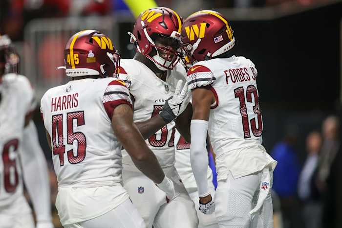 Oct 15, 2023; Atlanta, Georgia, USA; Washington Commanders linebacker Jamin Davis (52) reacts after an interception with linebacker De'Jon Harris (45) and cornerback Emmanuel Forbes (13) against the Atlanta Falcons in the second half at Mercedes-Benz Stadium.