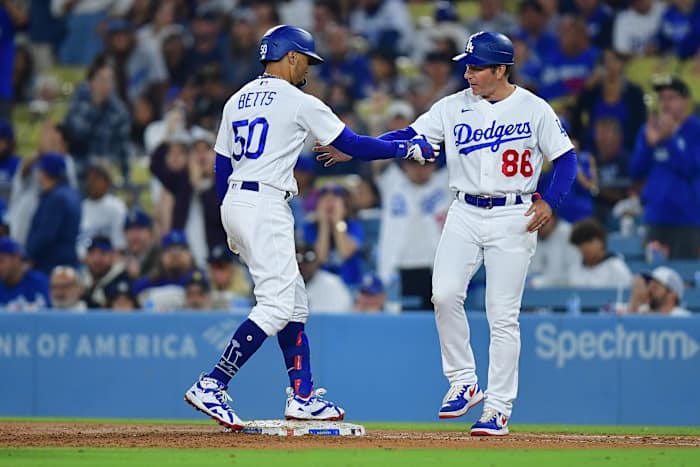 Sep 19, 2023; Los Angeles, California, USA; Los Angeles Dodgers second baseman Mookie Betts (50) is greeted by first base coach Clayton McCullough (86) after hitting a single against the Detroit Tigers during the seventh inning at Dodger Stadium.