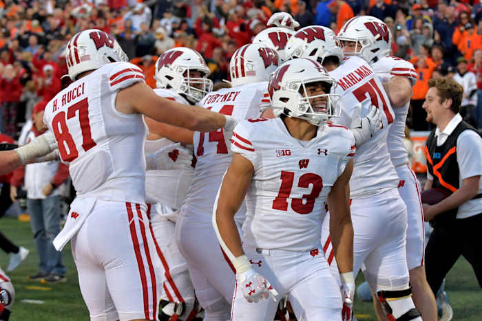 Oct 21, 2023; Champaign, Illinois, USA; Wisconsin Badgers players celebrate a touchdown during the second half against the Illinois Fighting Illini at Memorial Stadium. Mandatory Credit: Ron Johnson-USA TODAY Sports