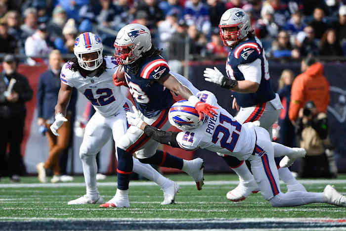 Patriots running back Rhamondre Stevenson sheds a tackle by Bills safety Jordan Poyer.
