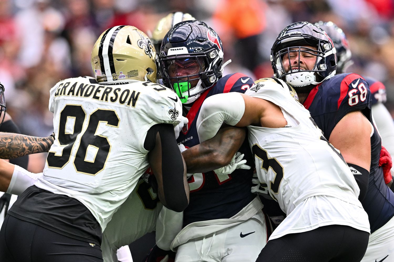Saints defensive tackles and cornerback wrap up Houston Texans running back Dameon Pierce during the first quarter at NRG Stadium.