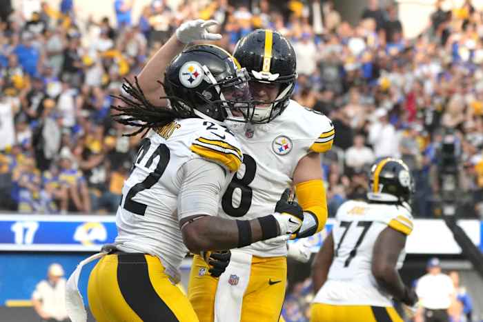 Kenny Pickett puts his hand on Najee Harris’s helmet as the two jump in celebration