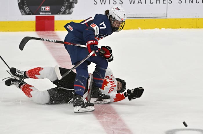 Apr 16, 2023; Brampton, Ontario, CAN; USA forward Britta Curl (17) knocks down Canada defender Ella Shelton (17) as they pursue the puck in the first period at CAA Center. Mandatory Credit: Dan Hamilton-USA TODAY Sports