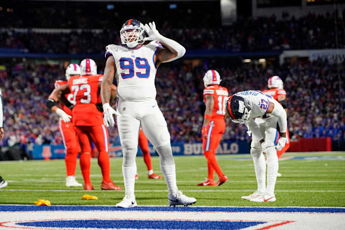 Leonard Williams stands near the endzone with his hand up by his ear taunting the crowd