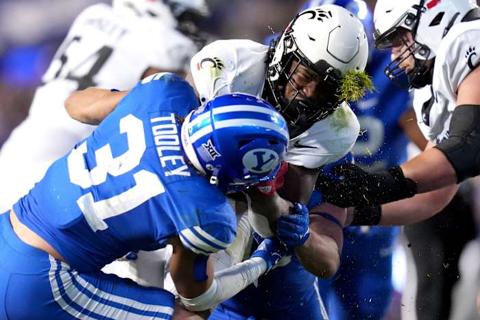 Cincinnati Bearcats running back Corey Kiner (21) is tackled by Brigham Young Cougars linebacker Max Tooley (31) in the third quarter during a college football game between the Brigham Young Cougars and Cincinnati Bearcats