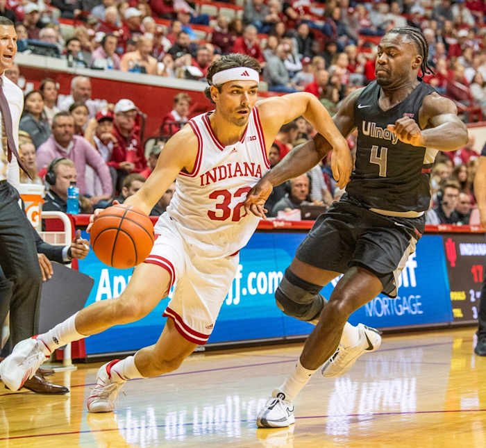 Indiana's Trey Galloway (32) drives past University of Indianapolis' Jarvis Walker (4) during the Indiana versus University of Indianapolis men's basketball game.