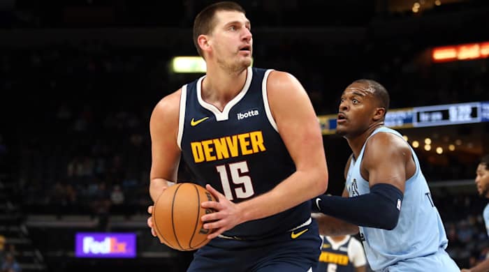 Denver Nuggets center Nikola Jokic spins toward the basket as Memphis Grizzlies forward Xavier Tillman defends.