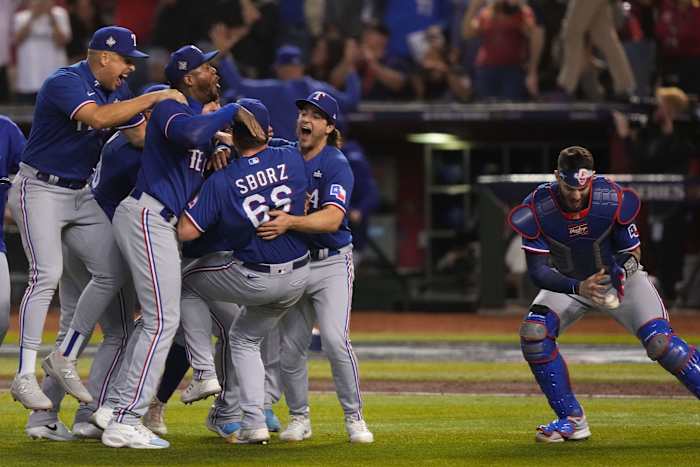 Texas Rangers catcher Jonah Heim, right, retrieves the game ball while celebrating after winning Game 5 of the 2023 World Series against the Arizona Diamondbacks at Chase Field in Phoenix on Nov. 1.