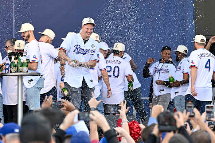 Nov 3, 2023; Arlington, TX, USA; Texas Rangers third baseman Josh Jung (6) sprays the crowd with champagne during the celebration outside of the ballpark after the World Series championship parade at Globe Life Field. Mandatory Credit: Jerome Miron-USA TODAY Sports