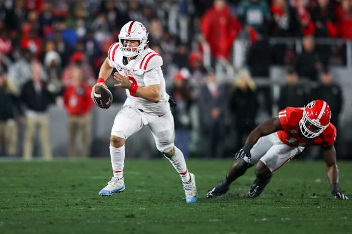 Mississippi Rebels quarterback Jaxson Dart (2) scrambles past Georgia Bulldogs linebacker Jalon Walker (11) in the first quarter at Sanford Stadium.