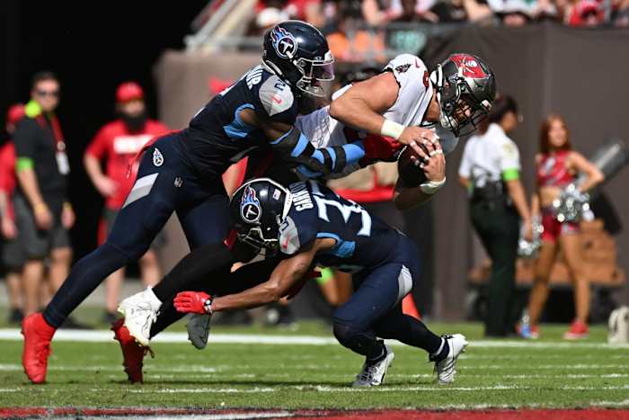 Tampa Bay Buccaneers tight end Cade Otoon (88) gets tackled by Tennessee Titans linebacker Azeez Al-Shaair (2) and Tennessee Titans defensive back Eric Garner (33).
