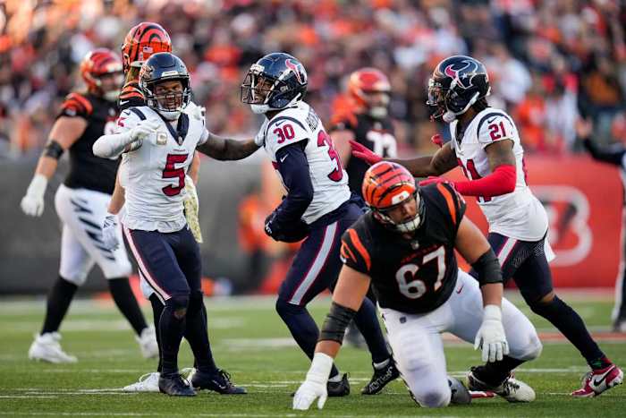 DeAndre Houston-Carson holds the ball and is flanked by two teammates on his side after an interception