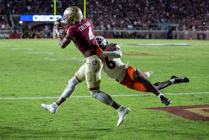Keon Coleman catches the ball while a defender grabs his torso to try to tackle him