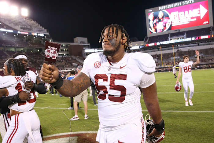 JC Latham rings a Mississippi state cowbell as he walks off the field