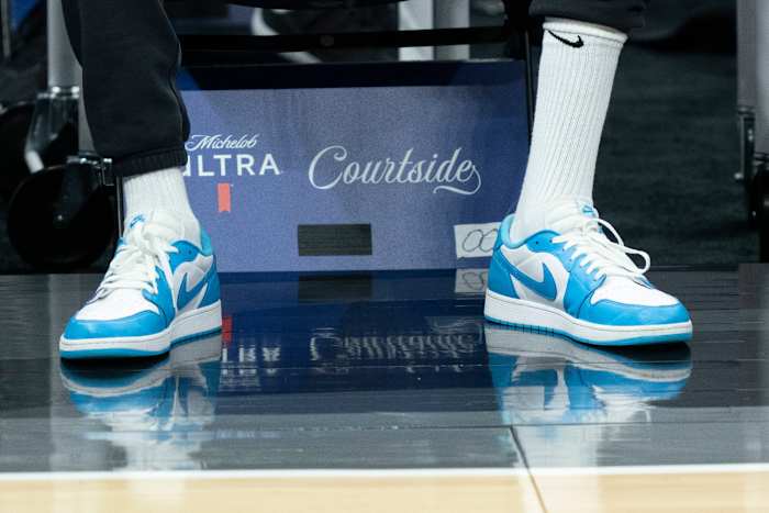 Kevin Durant wears blue and white Air Jordan sneakers on the sidelines of an NBA game.