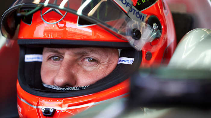 A close-up shot of Mercedes F1 driver Mick Schumacher with his team helmet on.