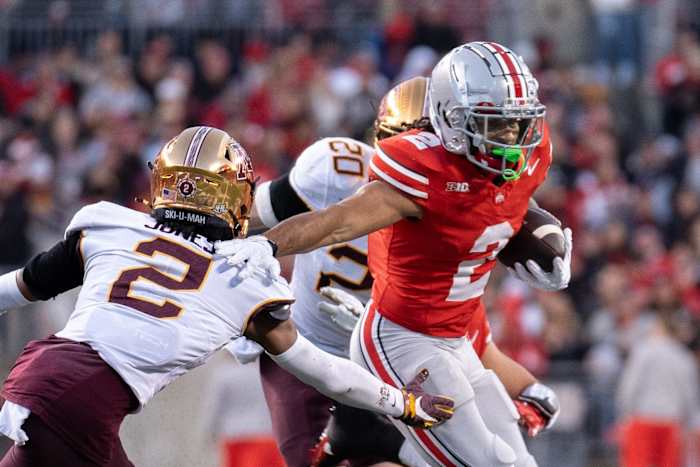 Nov 18, 2023; Columbus, Ohio, USA; Ohio State Buckeyes wide receiver Emeka Egbuka (2) runs past Minnesota Golden Gophers defensive back Tre'Von Jones (2) tackle attempt during the first half of their game on Saturday, Nov. 18, 2023 at Ohio Stadium.