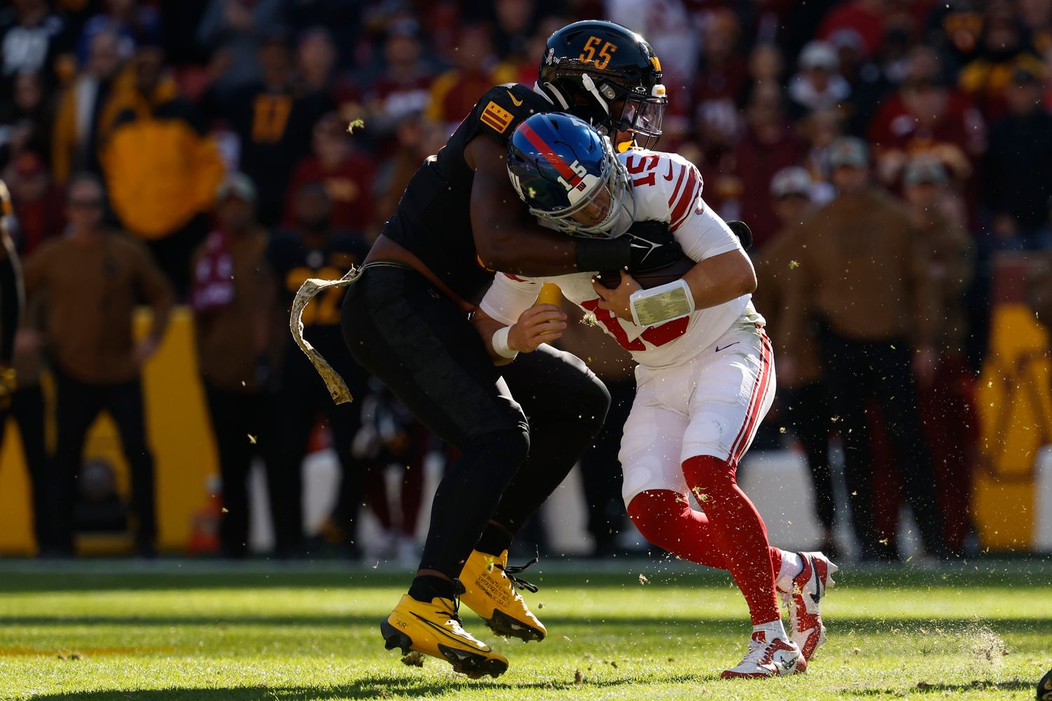 Washington Commanders defensive end KJ Henry (55) sacks New York Giants quarterback Tommy DeVito (15) during the first quarter at FedExField.