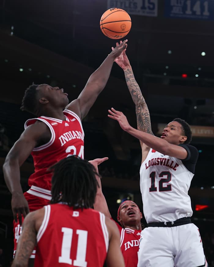 Louisville Cardinals forward JJ Traynor (12) shoots the ball as Indiana Hoosiers forward Payton Sparks (24) and guard CJ Gunn (11) defend during the first half at Madison Square Garden.
