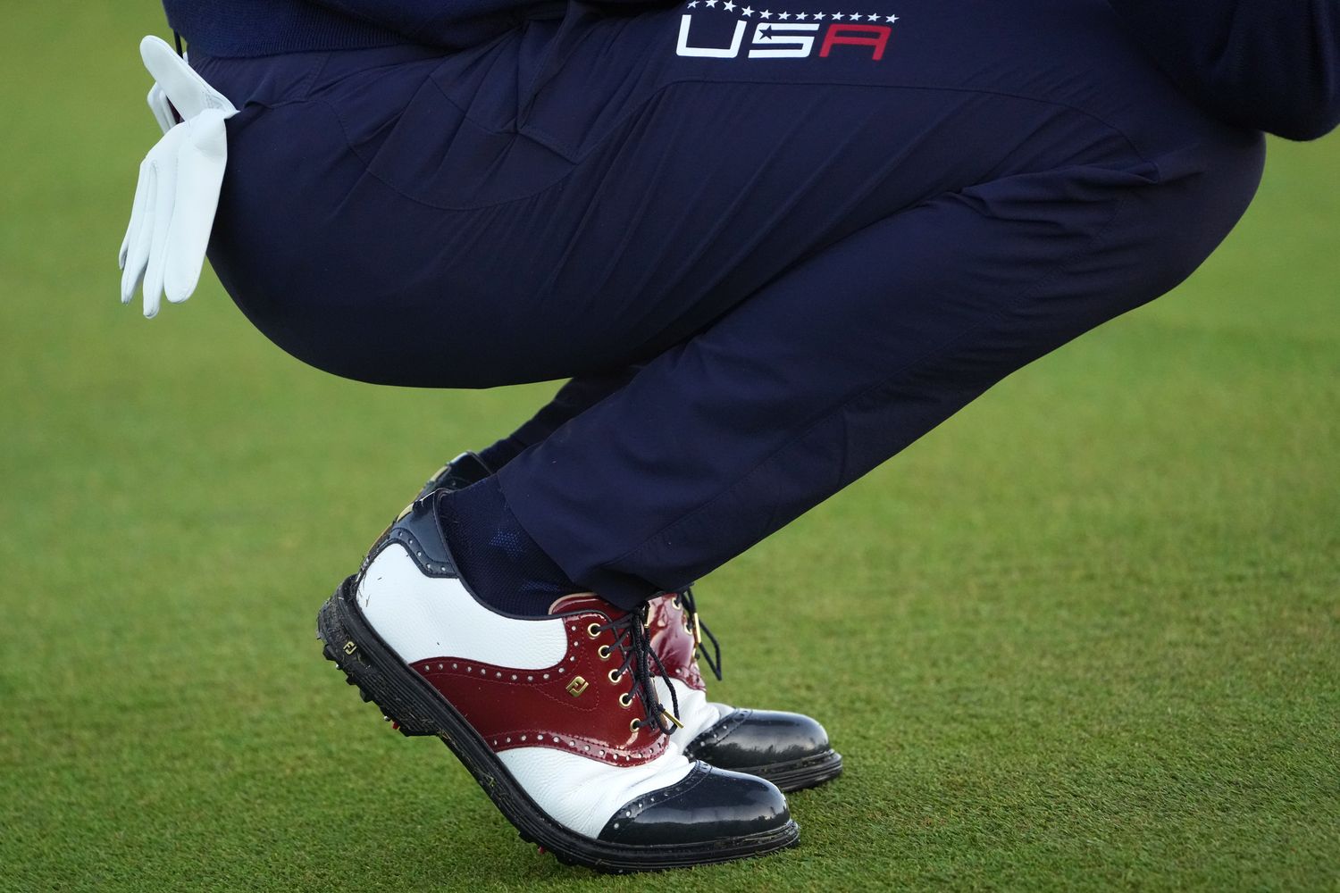 Side view of Justin Thomas' white and navy FootJoy golf shoes.