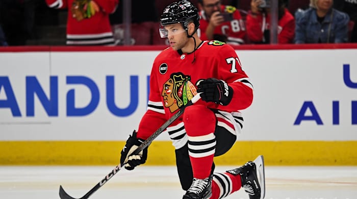 Blackhawks forward Taylor Hall kneels on the ices before a game.