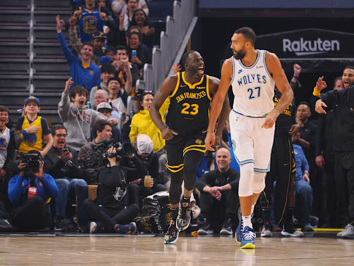 Nov 12, 2023; San Francisco, California, USA; Golden State Warriors forward Draymond Green (23) celebrates behind Minnesota Timberwolves center Rudy Gobert (27) after scoring a three point basket during the first quarter at Chase Center.