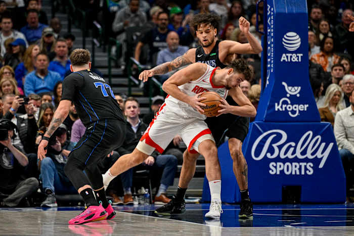 Rockets center Alperen Sengun looks to move to the basket past Dallas Mavericks guard Luka Doncic (77) and center Dereck Lively II (2) during the second quarter at the American Airlines Center.