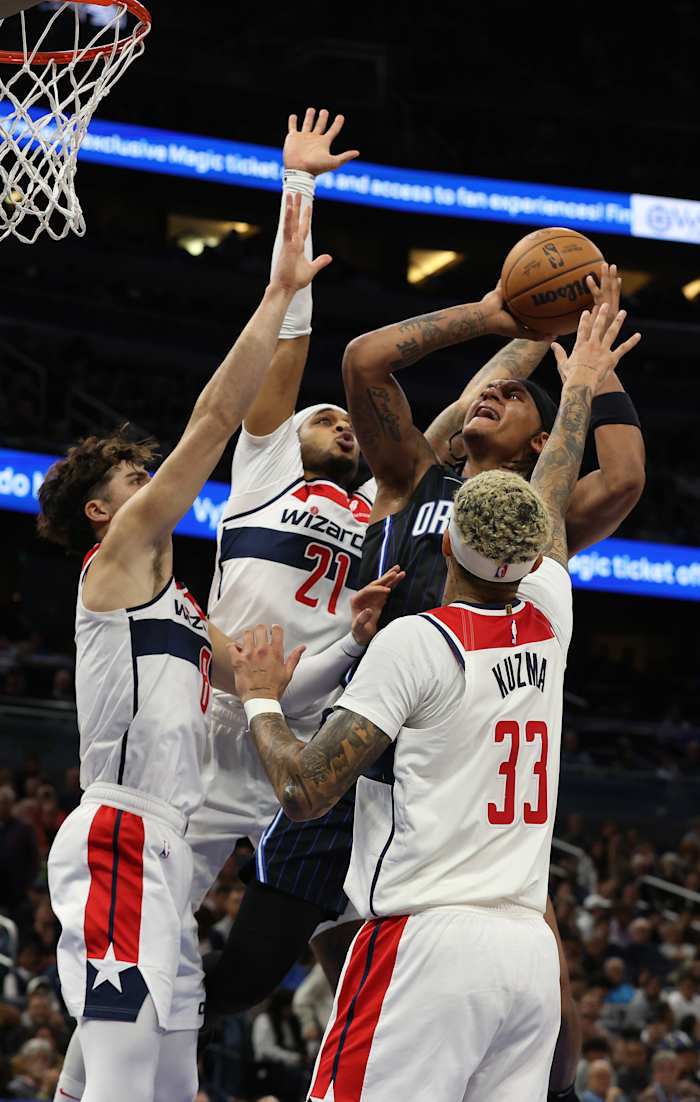 Orlando Magic forward Paolo Banchero (5) shoots as forward Deni Avdija (8), forward Kyle Kuzma (33) and Washington Wizards center Daniel Gafford (21) defend during the second quarter at Amway Center.