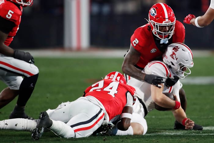 Georgia defensive back Malaki Starks (24) and Georgia linebacker Smael Mondon Jr. (2) take down Ole Miss quarterback Jaxson Dart (2) during the first half of a NCAA college football game against Ole Miss in Athens, Ga., on Saturday, Nov. 11, 2023.