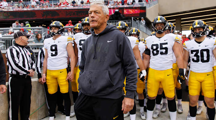 Iowa Hawkeyes head coach Kirk Ferentz looks on before taking the field with his team behind him.