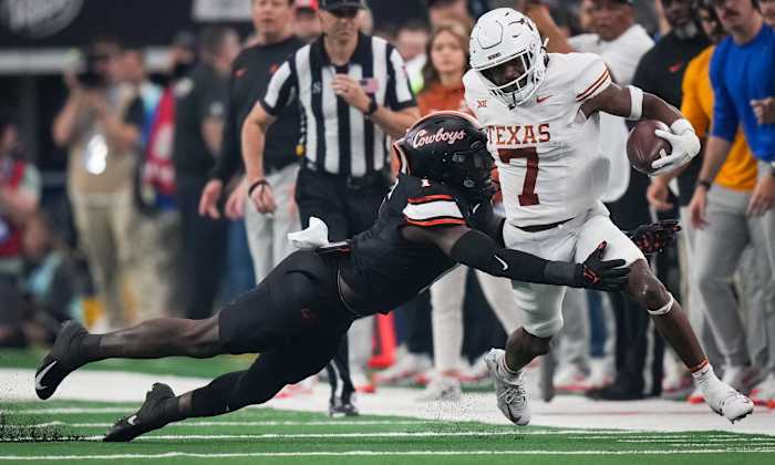 Oklahoma State linebacker Xavier Benson (1) dives to tackle Texas running back Keilan Robinson (7) in the first quarter of the Big 12 Conference Championship game at AT&T Stadium in Arlington, Texas, Saturday, Dec. 2, 2023