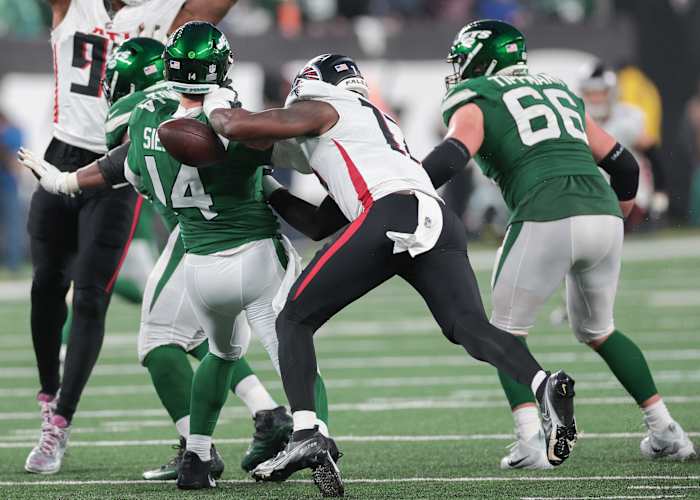 Dec 3, 2023; East Rutherford, New Jersey, USA; New York Jets quarterback Trevor Siemian (14) is hit by Atlanta Falcons linebacker Arnold Ebiketie (17) while throwing the ball during the second half at MetLife Stadium.