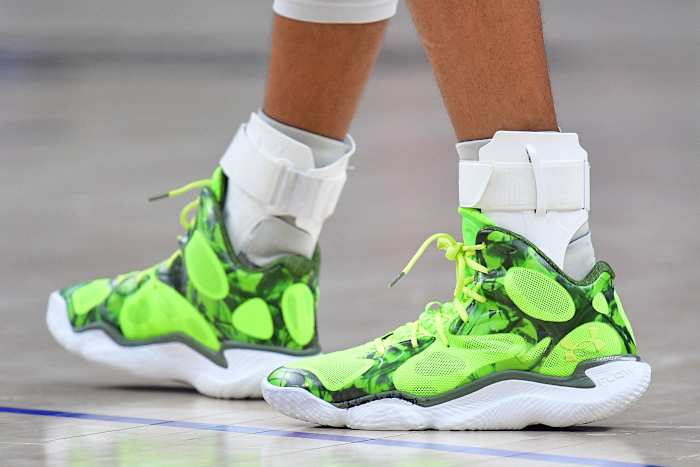 Golden State Warriors guard Stephen Curry's green and white Under Armour shoes.