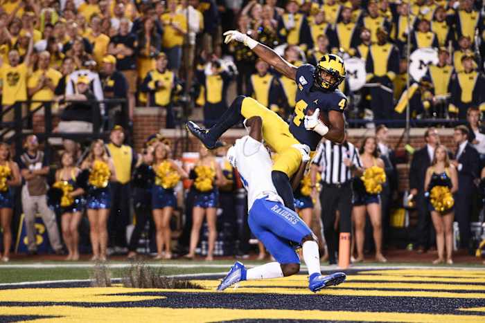 Nico Collins catches a touchdown pass as Blue Raiders safety Gregory Grate Jr attempts to break up the play during the second quarter at Michigan Stadium