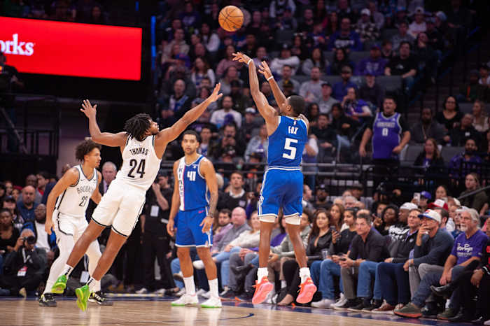 Sacramento Kings guard De'Aaron Fox (5) takes a three-point shot over Brooklyn Nets guard Cam Thomas (24
