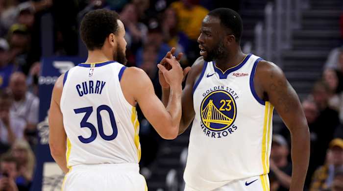 Warriors guard Stephen Curry congratulates forward Draymond Green during a game.