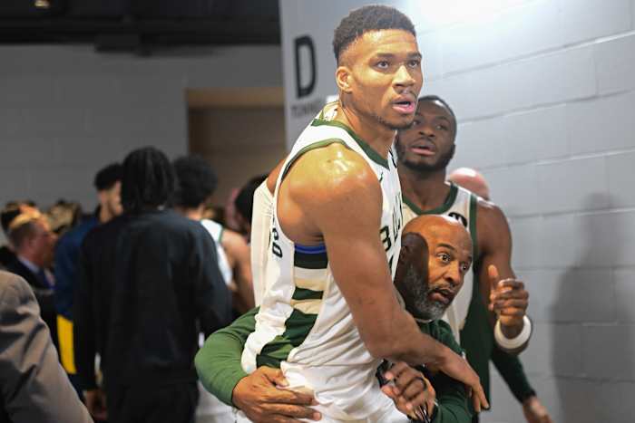 Milwaukee Bucks forward Giannis Antetokounmpo (34) is restrained by a coach outside the Indiana Pacers