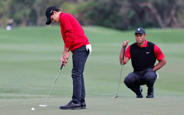 Dec 18, 2022; Orlando, Florida, USA; Charlie Woods (left) rolls a putt on the second hole as father Tiger Woods looks on during the final round of the PNC Championship golf tournament at Ritz Carlton Golf Club Grande Lakes Orlando Course. Mandatory Credit: Reinhold Matay-USA TODAY Sports