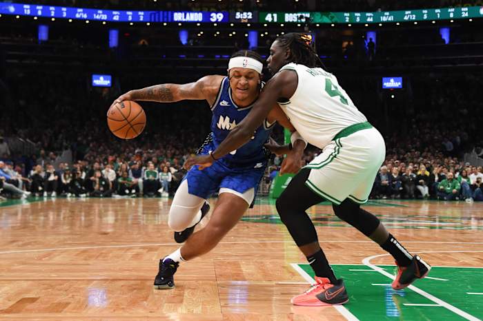 Dec 17, 2023; Boston, Massachusetts, USA; Orlando Magic forward Paolo Banchero (5) dribbles the ball while Boston Celtics guard Jrue Holiday (4) defends during the first half at TD Garden.