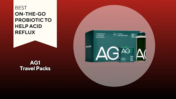 Green box next to a water bottle filled with green liquid. Both have white writing that says "AG1" on the label