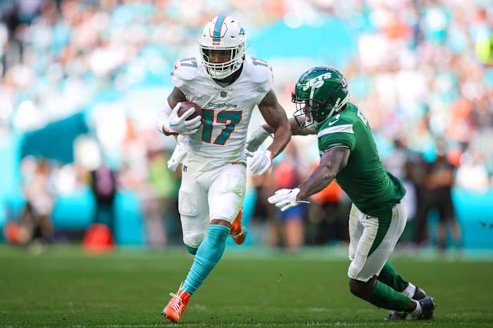 Dec 17, 2023; Miami Gardens, Florida, USA; Miami Dolphins wide receiver Jaylen Waddle (17) runs with the football past New York Jets cornerback D.J. Reed (4) during the second quarter at Hard Rock Stadium.