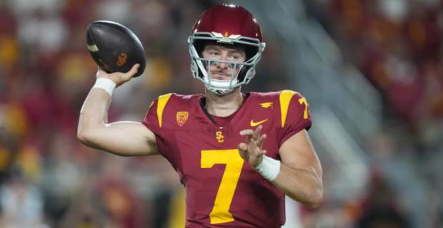 USC Trojans quarterback Miller Moss attempts a pass during a college football game.