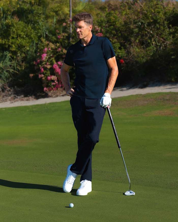 Tom Brady in a photo shoot on a golf course.