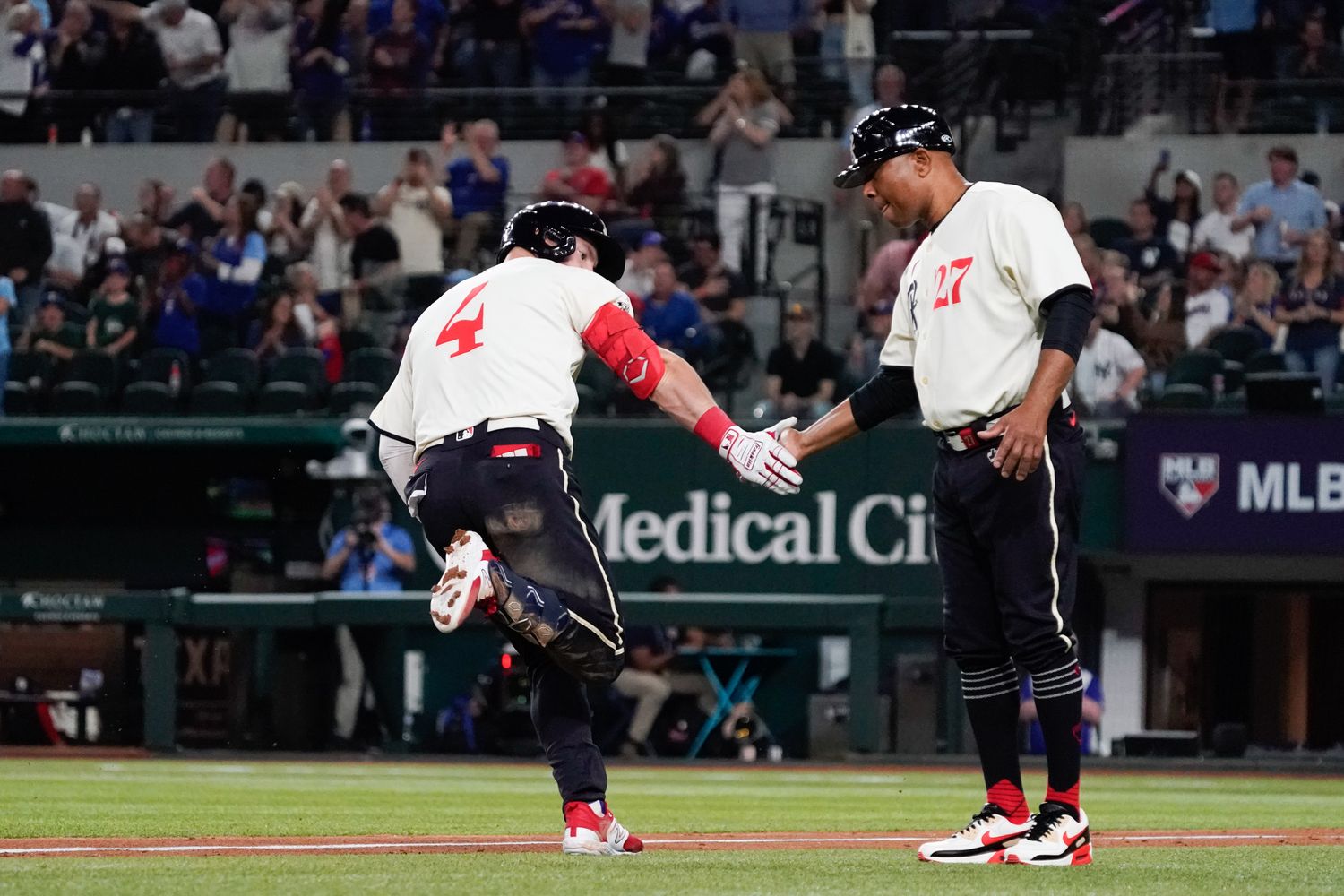 Texas Rangers right fielder Robbie Grossman celebrates with third base coach Tony Beasley as he circles the bases after a two-run home run against the New York Yankees on April 28 at Globe Life Field.
