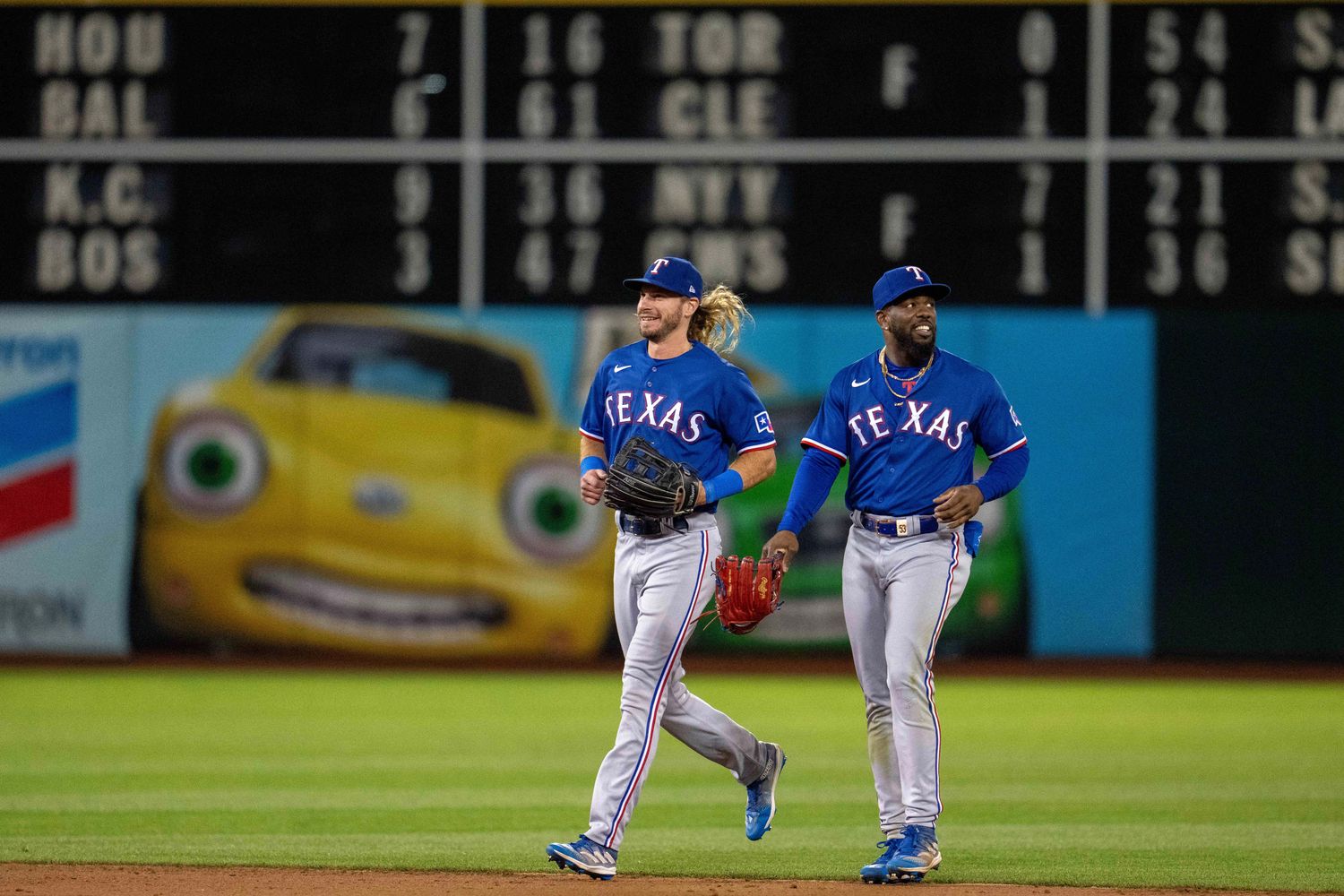 Texas Rangers left fielder Travis Jankowski, left, and right fielder Adolis Garcia celebrate after the club's eighth consecutive win to start August against the Oakland Athleticst on Aug. 8 at Oakland-Alameda County Coliseum.